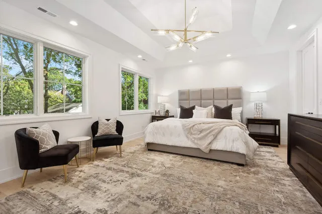 a bedroom with a large bed and a chandelier