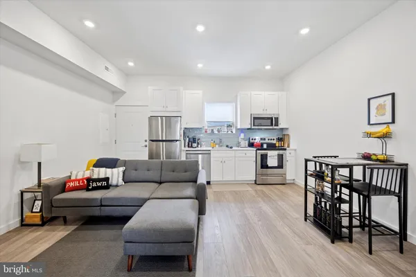 a living room with furniture and a wooden floor