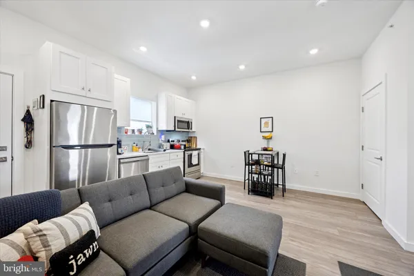a living room with furniture and a refrigerator