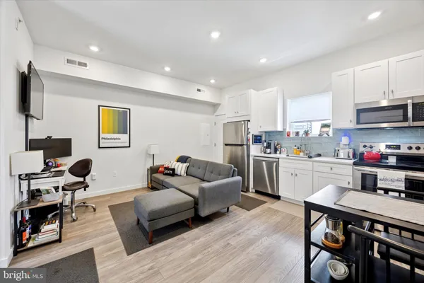 a living room with furniture and kitchen view