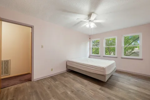 a spacious bedroom with a bed and a chandelier