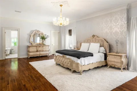 a spacious bedroom with a bed and a chandelier