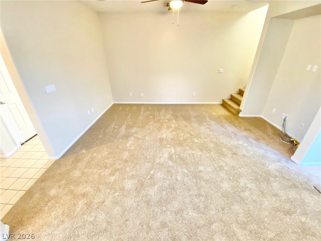 8569 Rhamus Court Las Vegas, NV 89149 - Photo 3 of 35 A spacious common area offers plush carpeting and a convenient staircase leading to the upper level.
