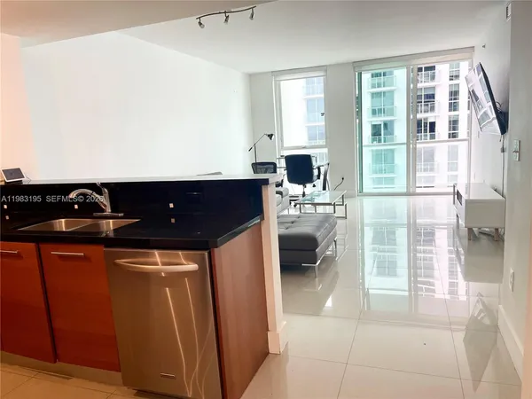 a living room with a flat screen tv and a floor to ceiling window