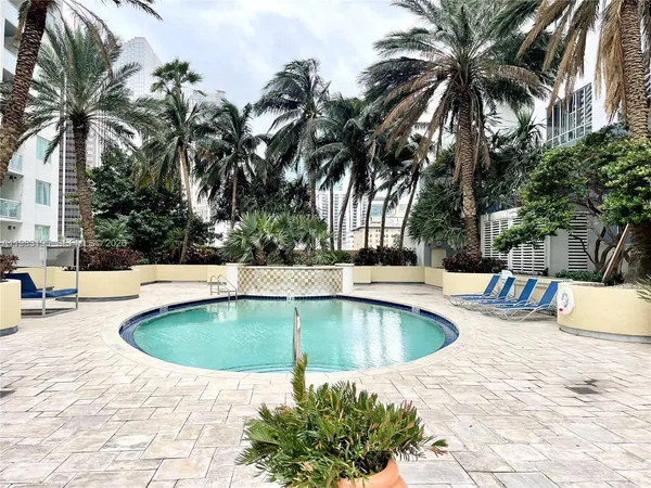 a view of a swimming pool with a patio and a fountain