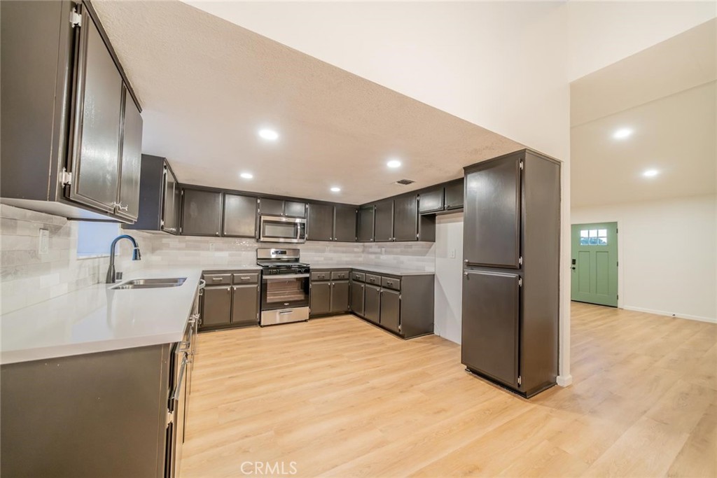 16754 Pauhaska Road Apple Valley, CA 92307 - Photo 7 of 19 a kitchen with stainless steel appliances kitchen island granite countertop a refrigerator a sink a stove and oven