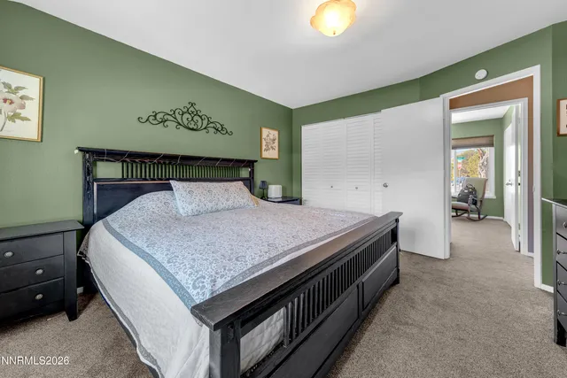 a spacious bedroom with a bed and painting on the wall