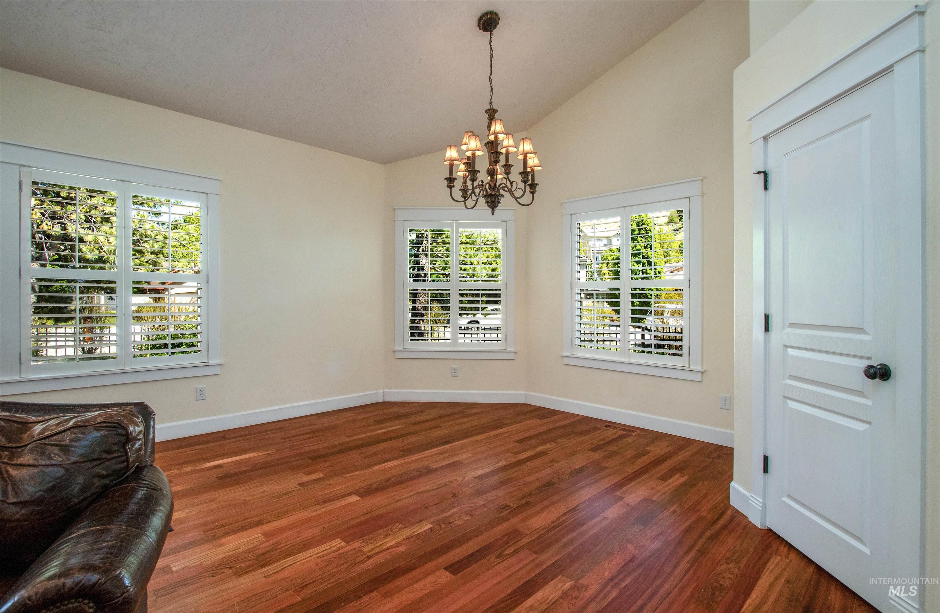 892 South Capitola Way Boise, ID 83712 - Photo 15 of 34 Spacious interior featuring wood-finish flooring, vaulted ceilings, and a bronze chandelier