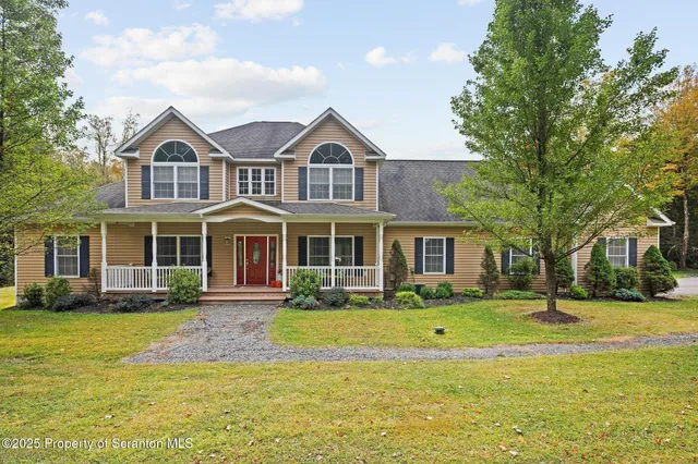aerial view of a house with a big yard and large trees