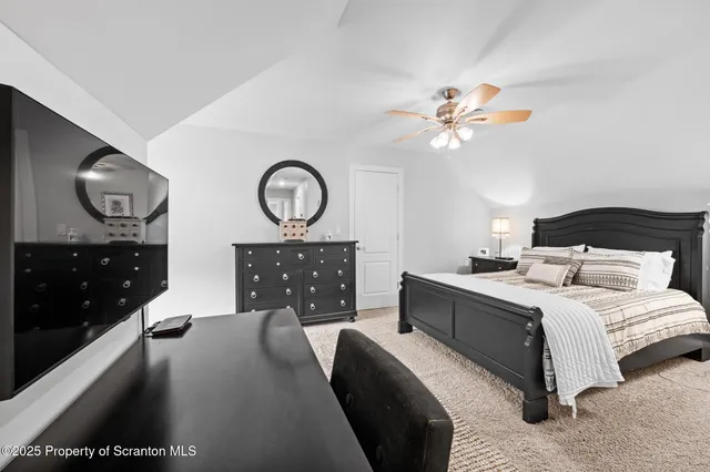 a spacious bedroom with a bed and a chandelier