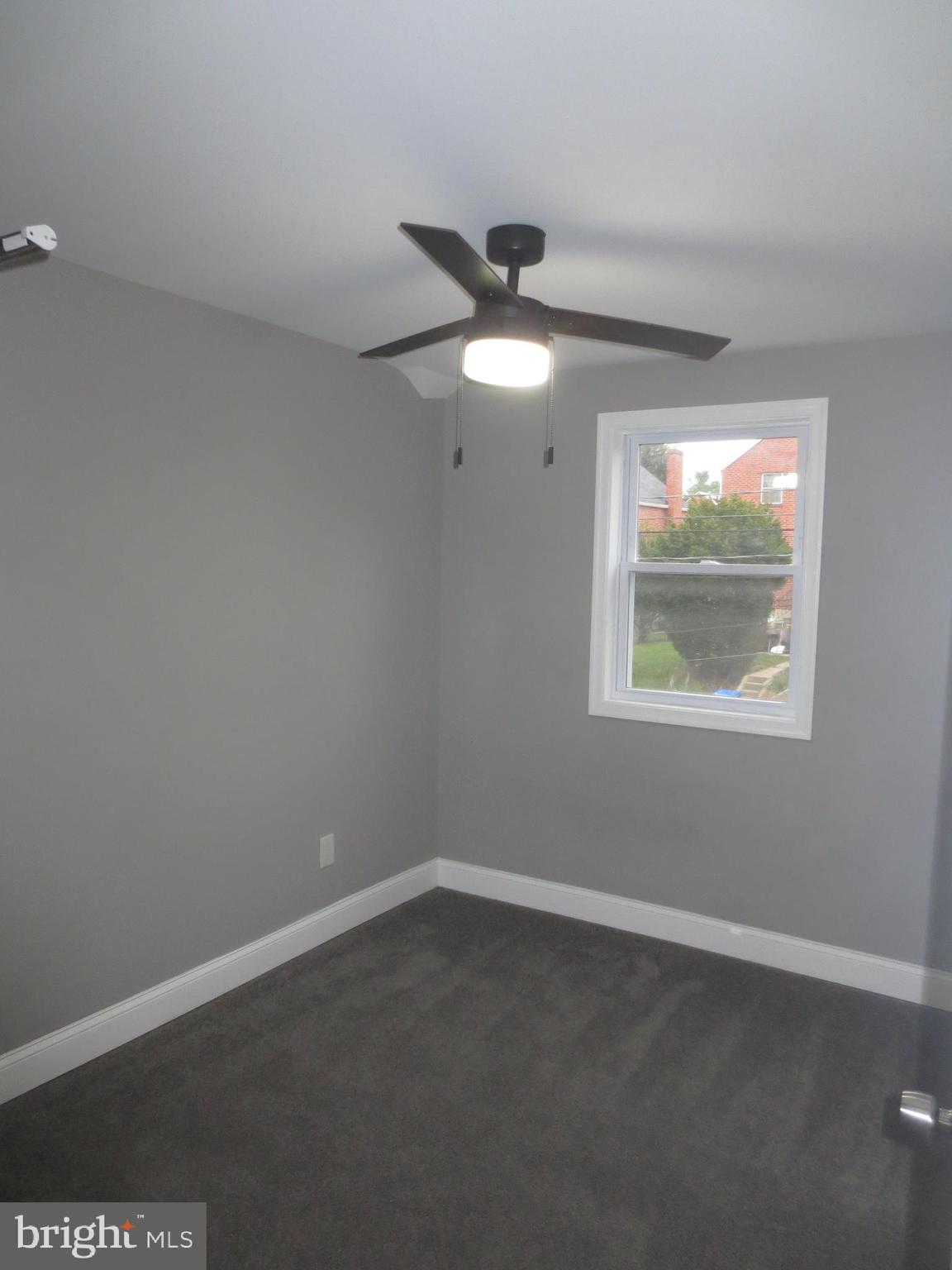 2027 Ramblewood Road Baltimore, MD 21239 - Photo 8 of 17 an empty room with windows and fan