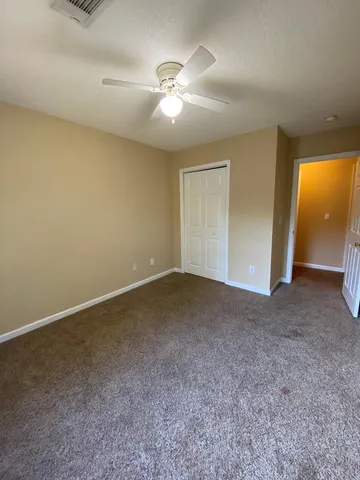 an empty room with a window and a ceiling fan