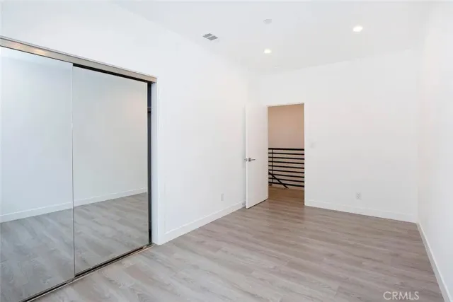 an empty room with wooden floor and entryway