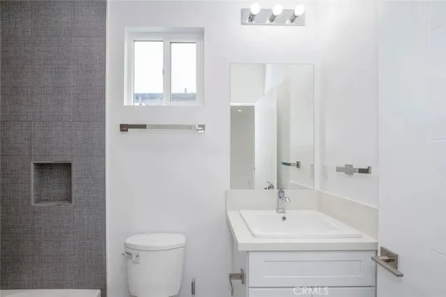 a bathroom with a sink a toilet and shower