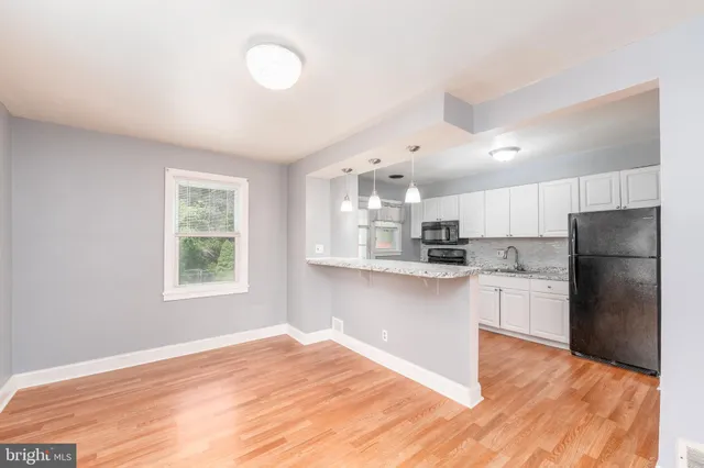 a kitchen with a refrigerator and a stove top oven