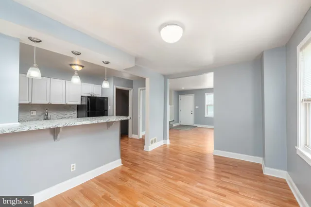 a view of kitchen with stainless steel appliances granite countertop a sink and cabinets