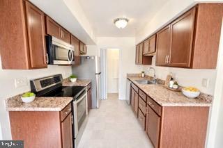 14905 Cleese Court, Unit E Silver Spring, MD 20906 - Photo 5 of 10 a kitchen with granite countertop a sink stove and cabinets