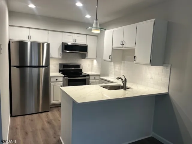 a kitchen with kitchen island a refrigerator sink and stove