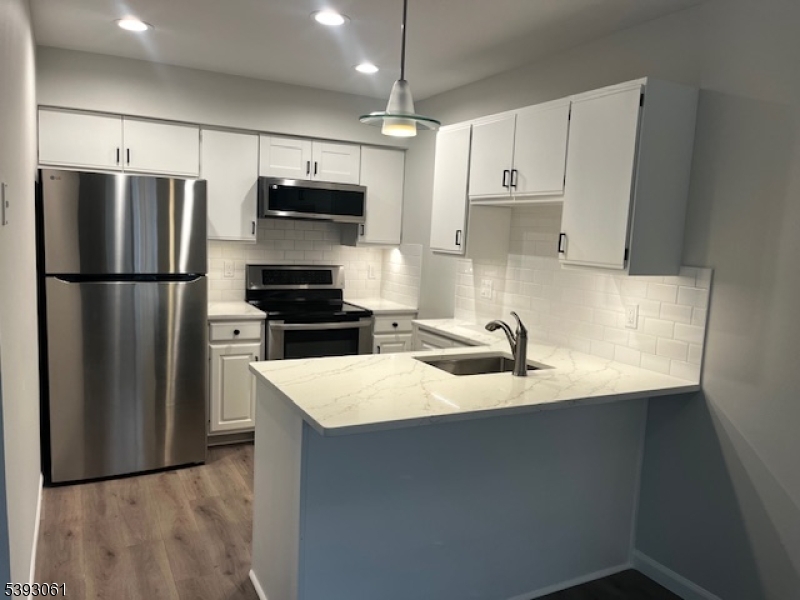 a kitchen with kitchen island a refrigerator sink and stove