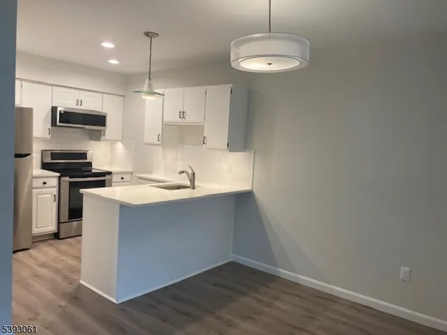 a kitchen with kitchen island a sink stainless steel appliances and cabinets