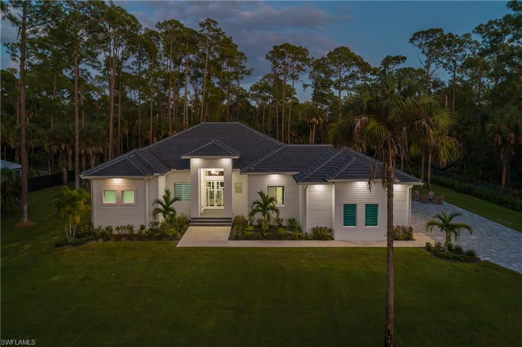 788 9th Street Southwest Naples, FL 34117 - Photo 2 of 46 a front view of a house with a garden