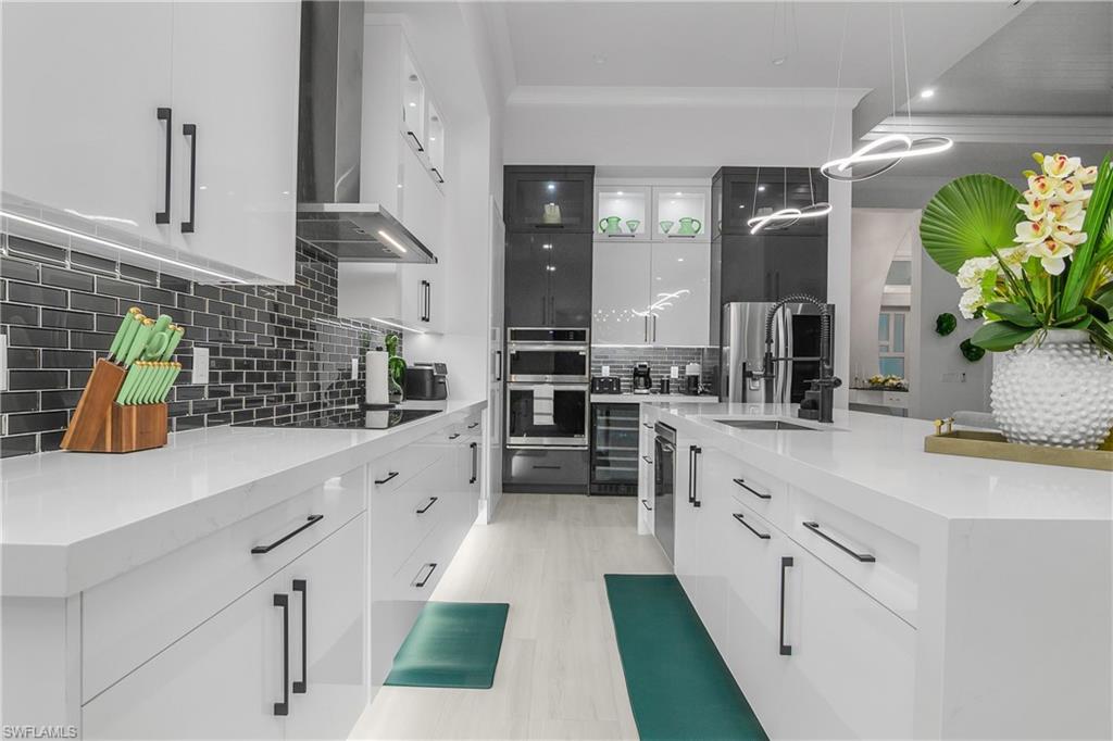 788 9th Street Southwest Naples, FL 34117 - Photo 25 of 46 a kitchen with stainless steel appliances kitchen island granite countertop a sink a counter top space and cabinets