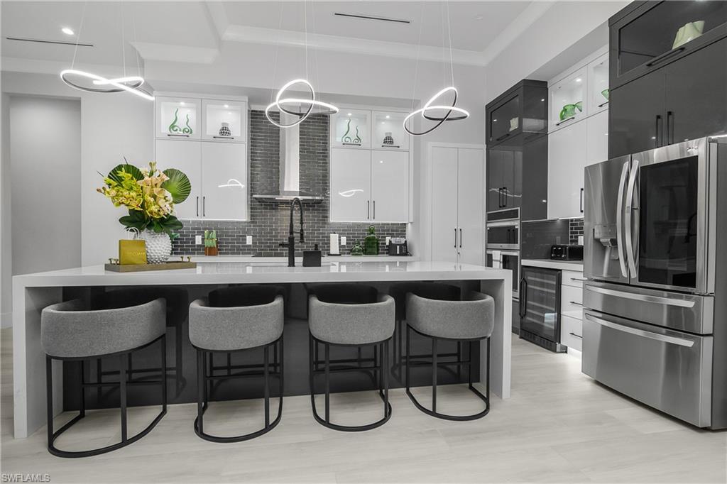 788 9th Street Southwest Naples, FL 34117 - Photo 27 of 46 a kitchen with granite countertop a table chairs stove and refrigerator