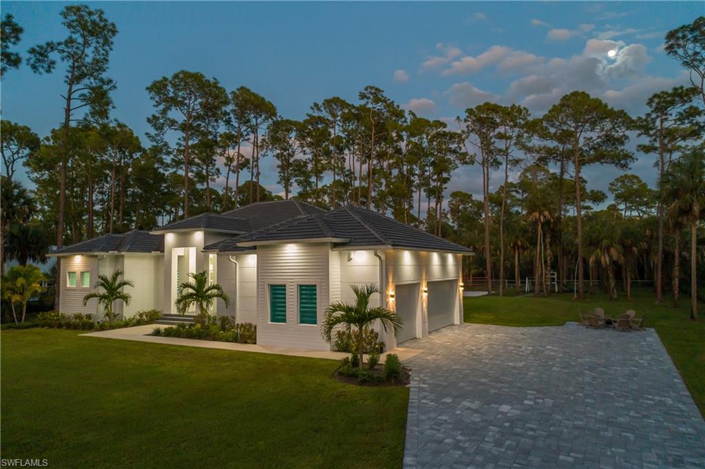 788 9th Street Southwest Naples, FL 34117 - Photo 3 of 46 a view of a patio with table and chairs under an umbrella with large trees