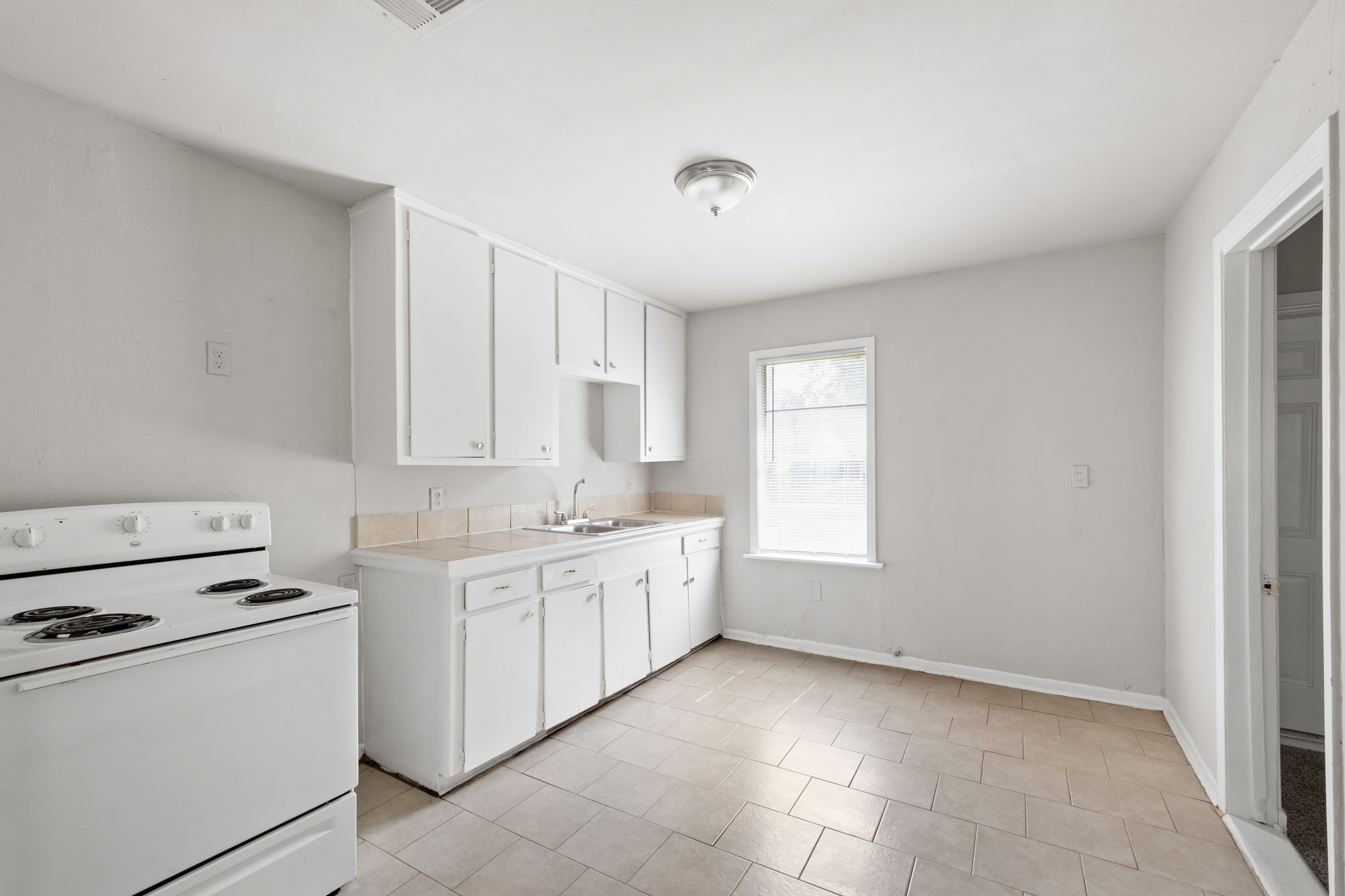 4922 Alvin Street Houston, TX 77033 - Photo 3 of 10 a kitchen with cabinets appliances a sink and a window