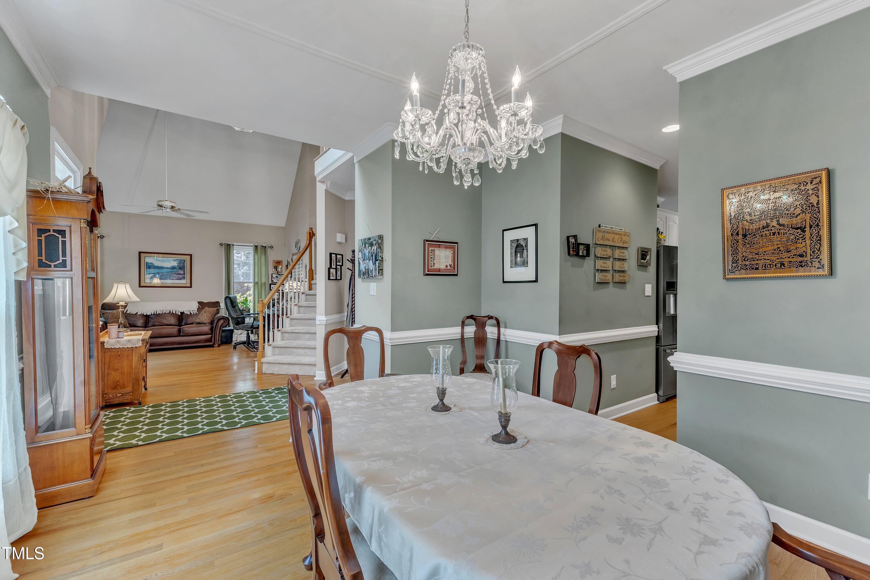 7613 Percy Court Raleigh, NC 27613 - Photo 11 of 51 a view of a dining room with furniture a chandelier and wooden floor
