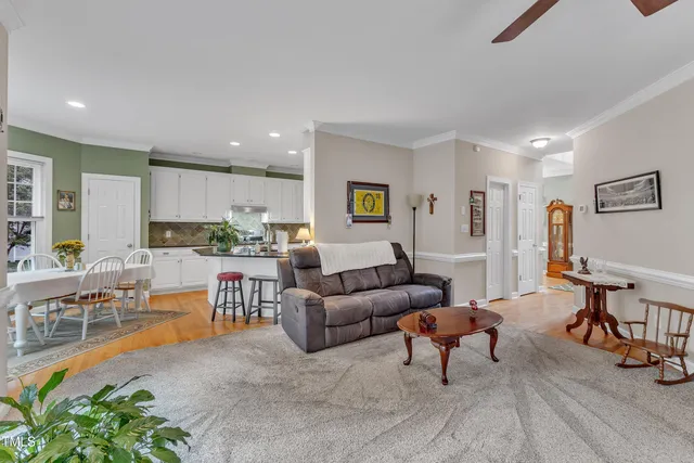 a living room with furniture and a dining table with kitchen view
