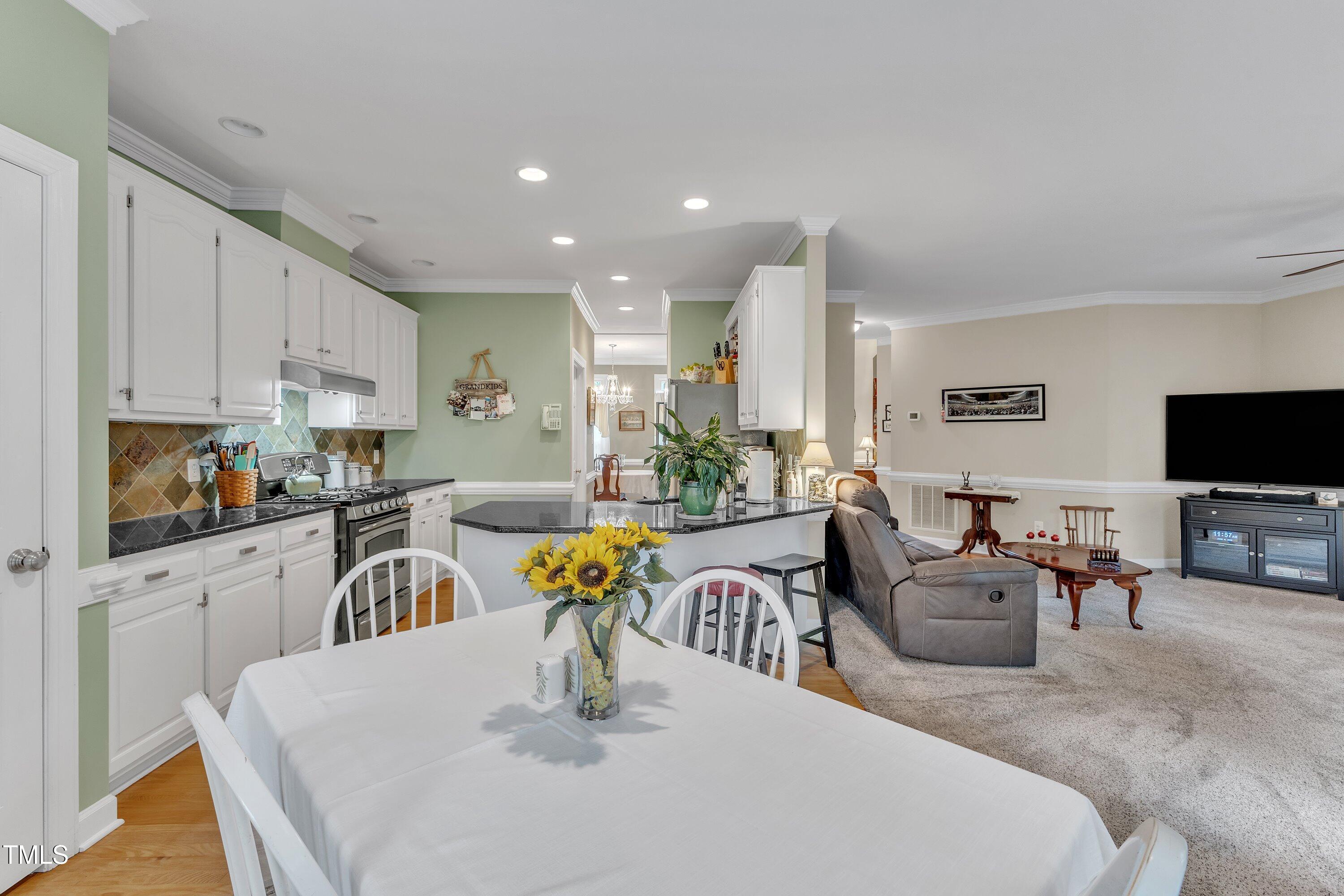 7613 Percy Court Raleigh, NC 27613 - Photo 20 of 51 a kitchen with stainless steel appliances granite countertop a table and chairs in it
