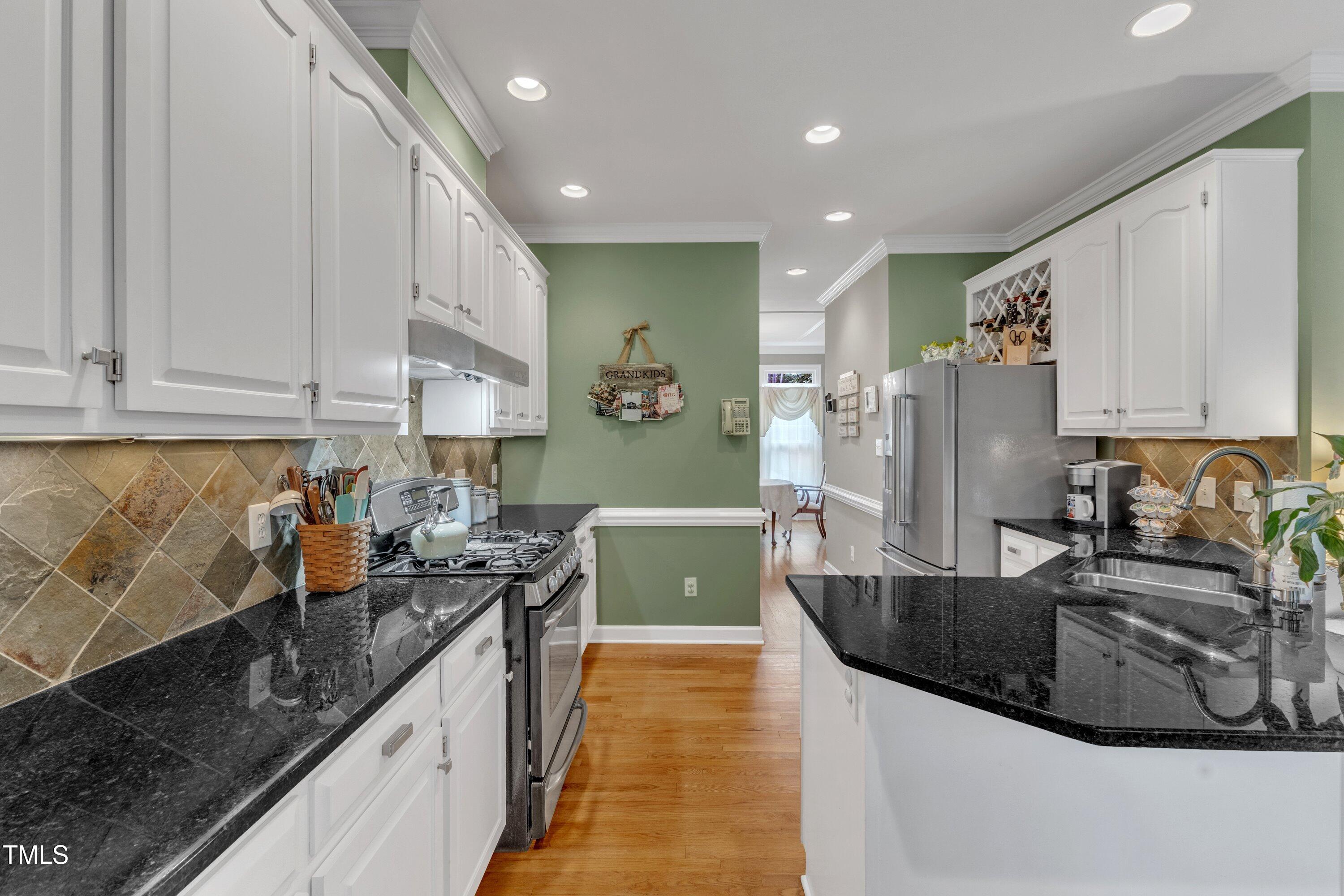 7613 Percy Court Raleigh, NC 27613 - Photo 22 of 51 a kitchen with stainless steel appliances granite countertop a sink a stove and a refrigerator