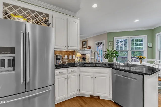a kitchen with stainless steel appliances granite countertop a refrigerator and a sink