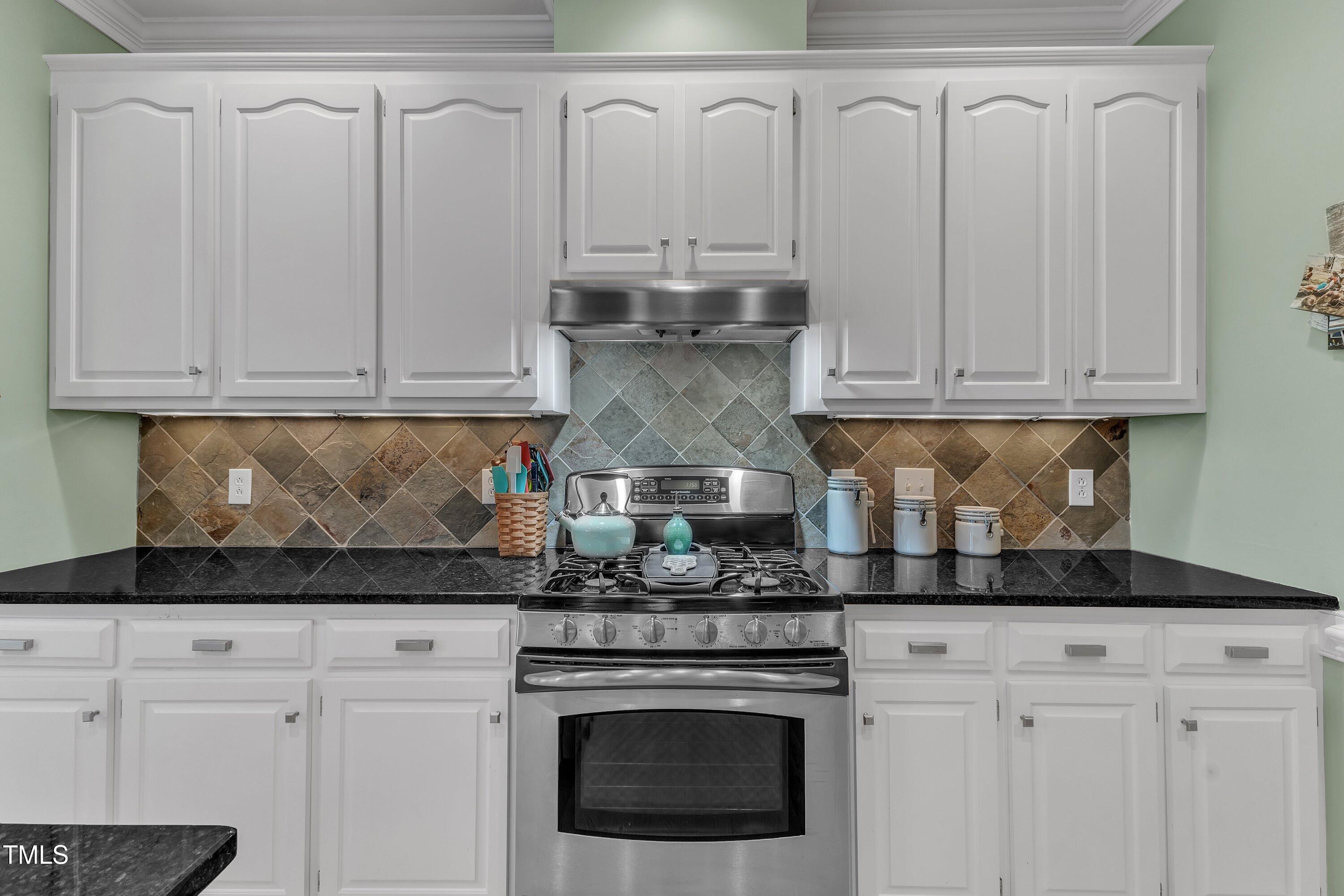 7613 Percy Court Raleigh, NC 27613 - Photo 25 of 51 a kitchen with white cabinets and appliances