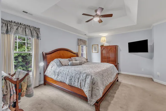 a bedroom with a bed window and a flat screen tv