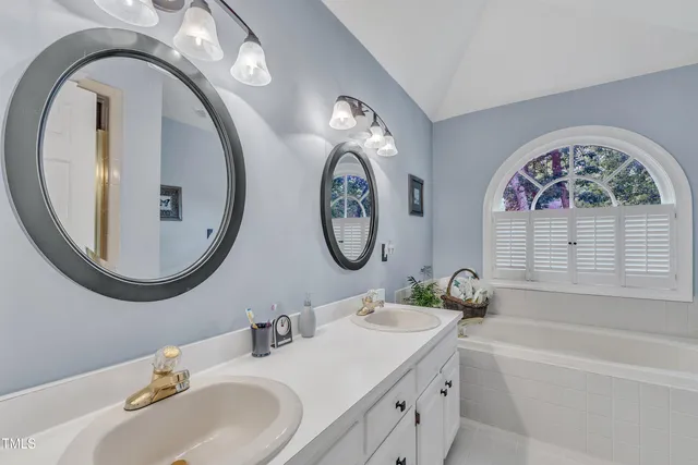 a bathroom with a granite countertop double vanity sink and a mirror