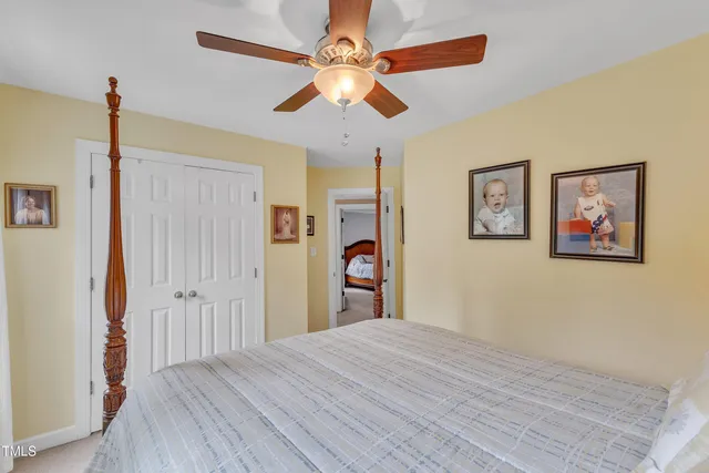 a bedroom with bed and paintings on the wall