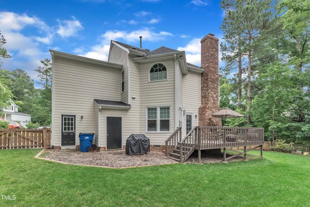 a backyard of a house with table and chairs with wooden fence