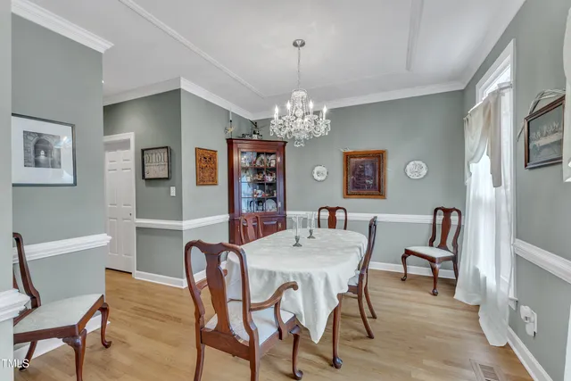 a view of a dining room with furniture and chandelier