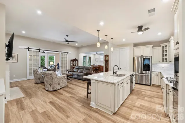 a living room with stainless steel appliances kitchen island furniture and a view of kitchen