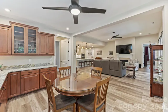 a view of a dining room with furniture a kitchen and chandelier