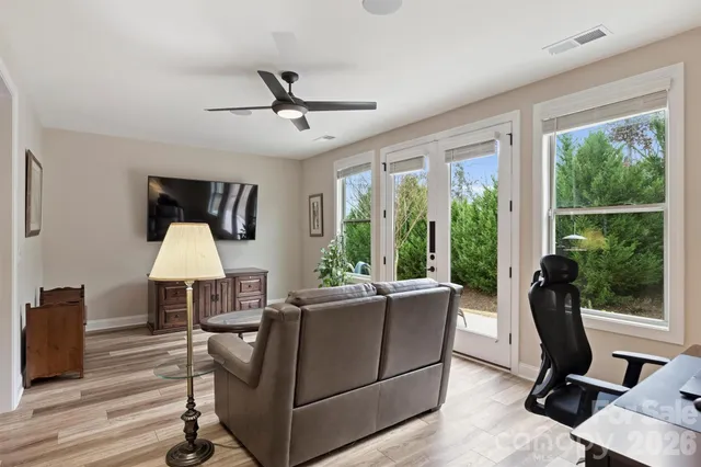 a living room with furniture a flat screen tv and a large window