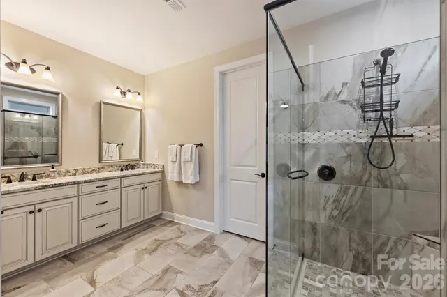 a spacious bathroom with a granite countertop sink mirror and shower