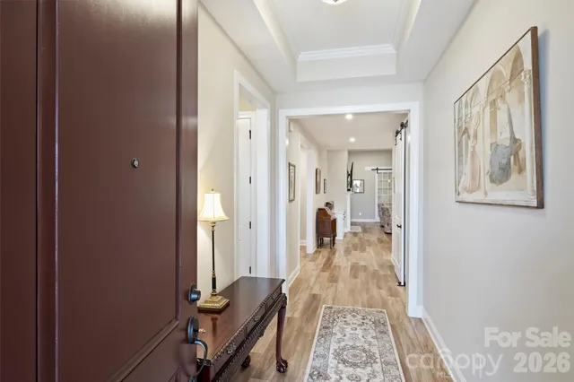 a view of a hallway with furniture and wooden floor