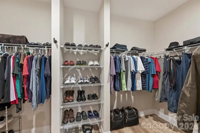 a view of walk in closet with clothes and shoes