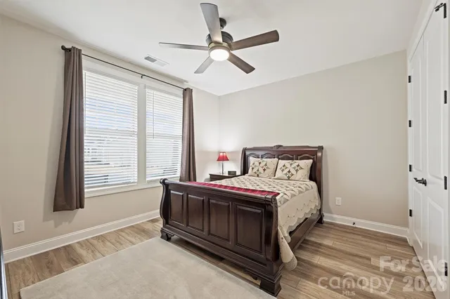 a bedroom with a bed next to a window with a chandelier