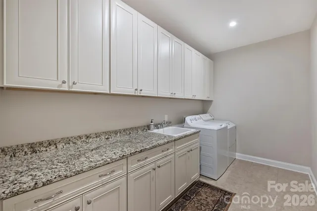 a kitchen with granite countertop white cabinets and sink