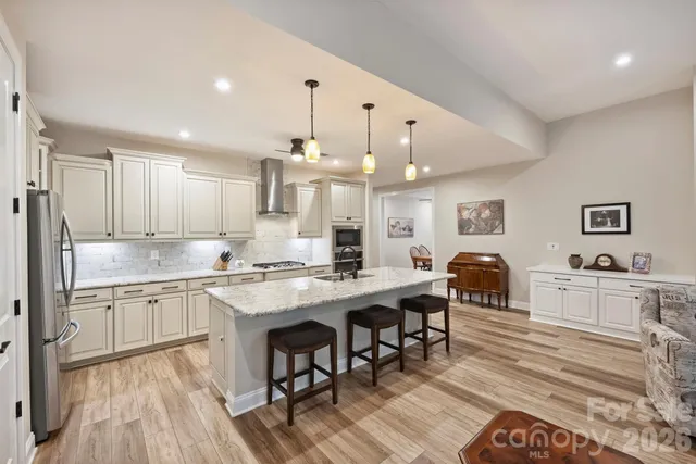 a kitchen with stainless steel appliances granite countertop a lot of counter space and wooden floors