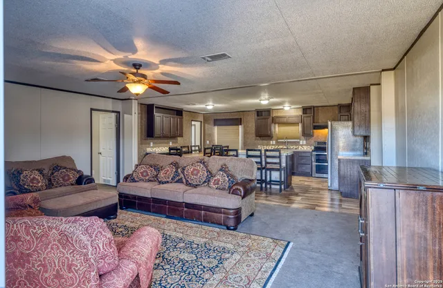 a living room with furniture kitchen view and a table